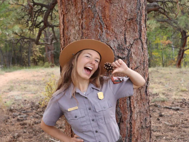 Ashley Jacobson poses in her park uniform in front of a large tree
