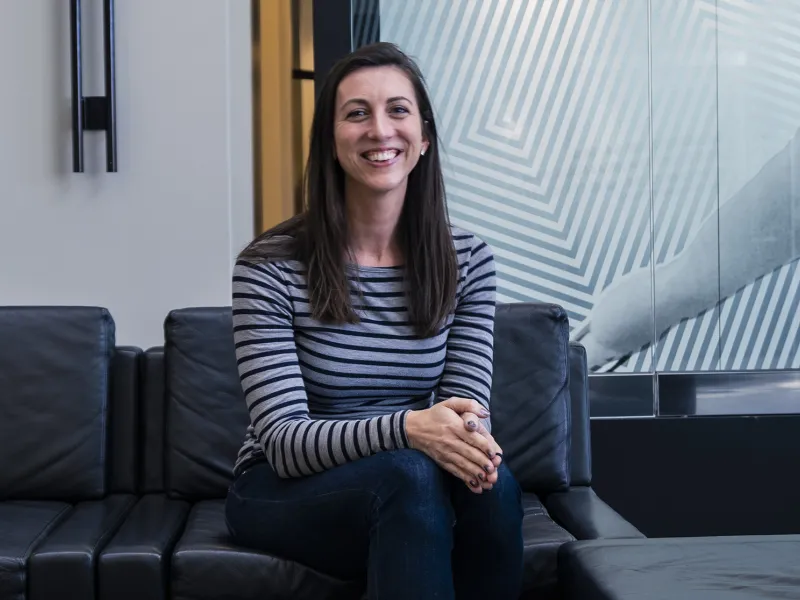 Camille Carbajal sits on a couch in an office