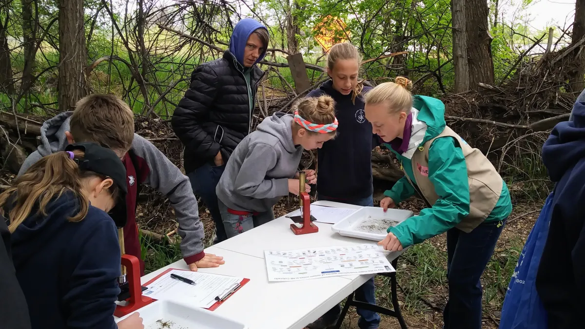 Volunteer instructor working with students in our River Lab station.