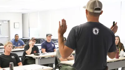 A Bureau of Land Management specialist stands in front of a class of participants