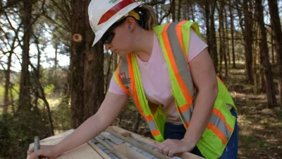 A geologist looks over a plan while in the forest