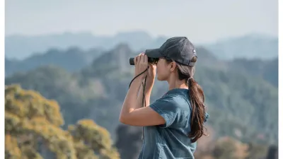 Woman with binoculars looking out at landscape