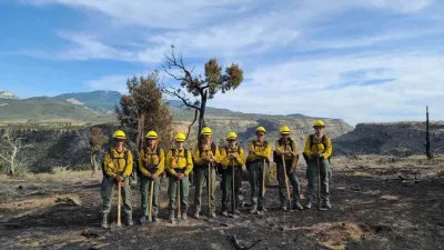 A group of wildland firefighters poses for a photo after extinguishing a small brush fire