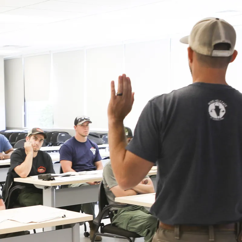 A Bureau of Land Management specialist stands in front of a class of participants