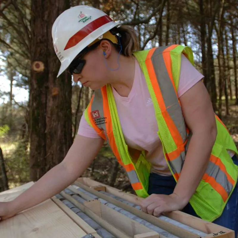 A geologist looks over a plan while in the forest