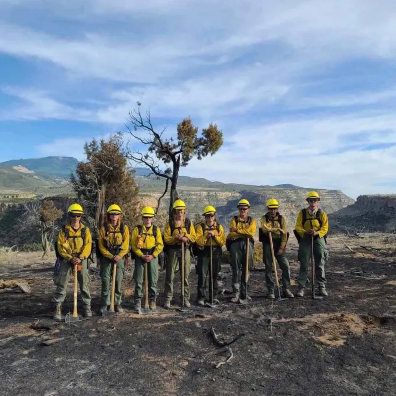 A group of wildland firefighters poses for a photo after extinguishing a small brush fire